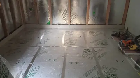 Izolační desky položené na podlaze v rozpracovaném podkroví.
