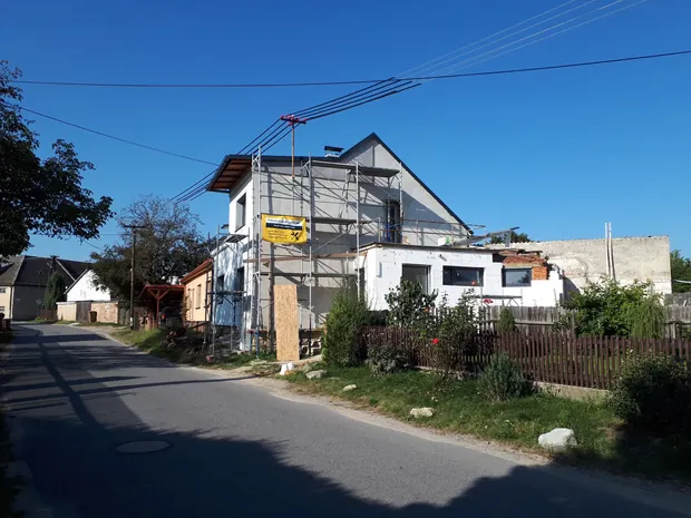 Pohled na rozpracovanou fasádu domu z ulice.
