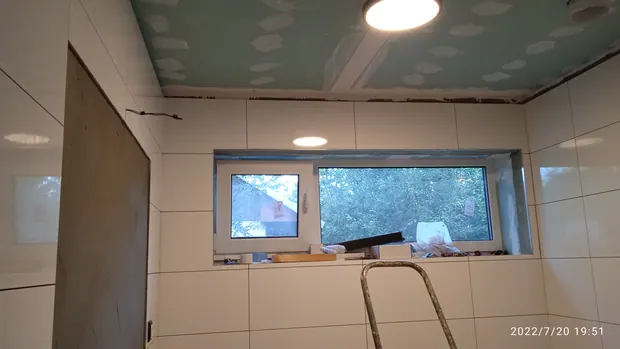 Okno, obklady a rozpracovaný strop přízemní koupelny.