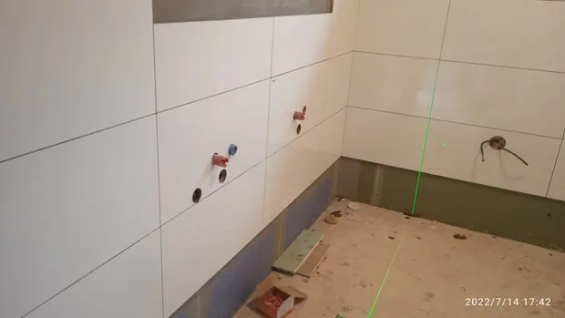 Příprava instalací a pokládka obkladů před osazením vybavení.