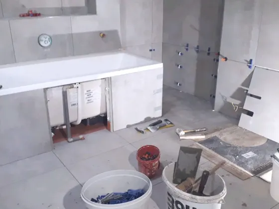 Průběh montáže vany a navazujících obkladů v jedné z koupelen.