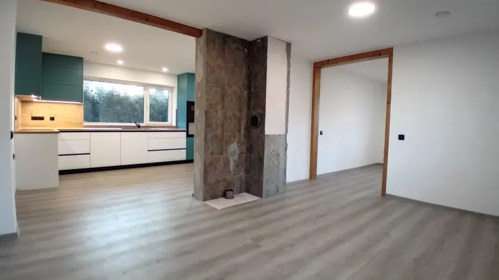 Hotový obytný prostor s kombinací světlých povrchů a dřeva.