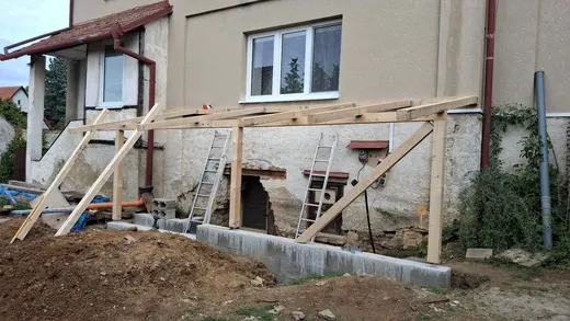 Montáž nosné dřevěné konstrukce pergoly nad sklepním vstupem.