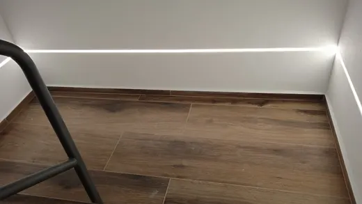 Detail velkoformátové dlažby na podestě a LED linie podél stěn.