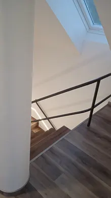 Nové střešní okno přivádí denní světlo k horní části schodiště.