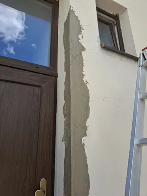 Srovnání a zpevnění ostění u dveří při opravě fasády.