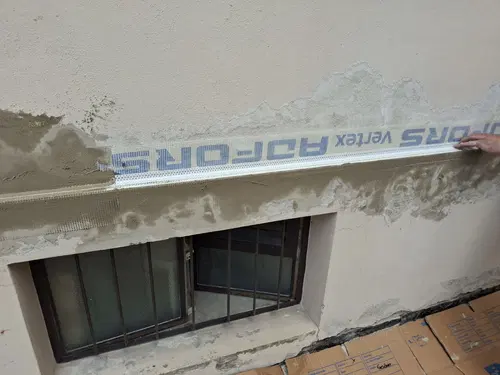 Detail výztužné síťky v opravované části fasády.
