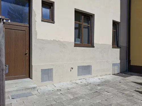 Opravená dvorní fasáda po doplnění podkladu, před sjednocujícím nátěrem.