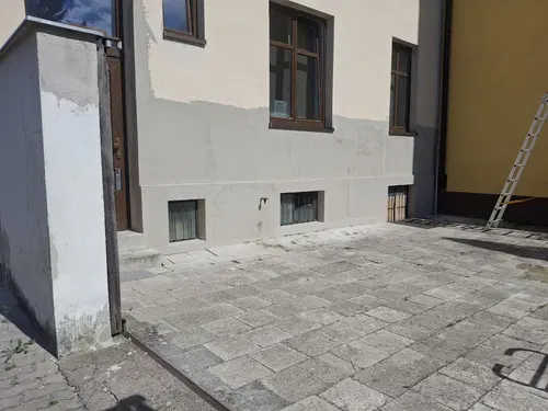 Dvorní fasáda a navazující stěna během přípravy na závěrečný nátěr.