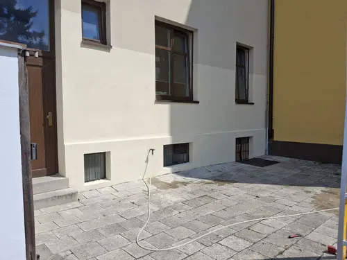 Dokončená dvorní fasáda s opraveným soklem a nátěrem.