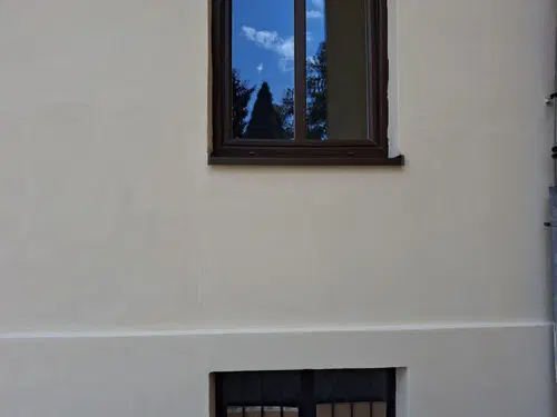 Detail opravené omítky a sjednoceného fasádního nátěru.