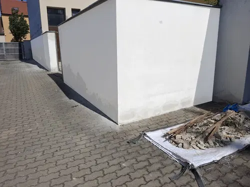 Dokončená navazující bílá stěna ve dvoře.