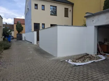 Po opravě: pohled do dvora s dokončenými bílými stěnami.
