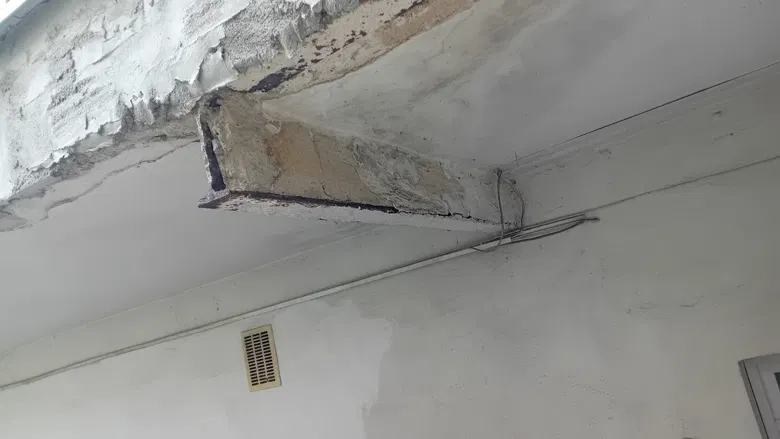 Poškozený beton spodní hrany terasy před opravou.