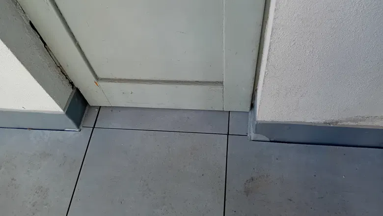 Napojení dlažby u prahu a stěny.