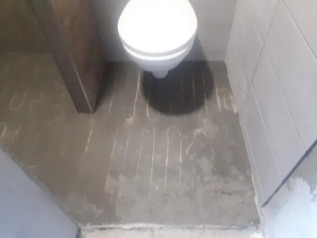 Příprava podlahy u závěsného WC před dokončením.