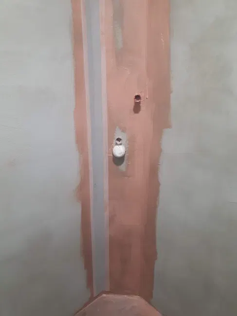 Úprava svislého rohu sprchového koutu před dokončením.
